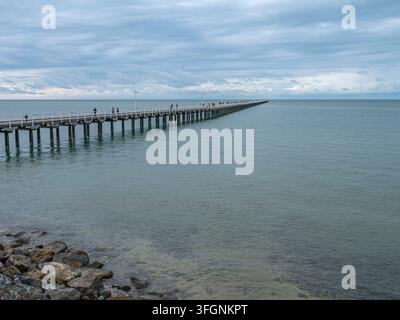 Lungo molo di legno che si estende nelle acque calme dell'oceano sulla costa australiana Foto Stock