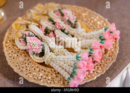 Ghirlande tradizionali di fiori di gelsomino thailandesi Phuang Malai su un vassoio decorativo d'oro Foto Stock