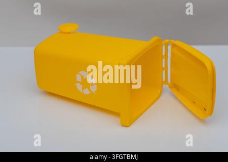 Cestino per il riciclo giallo con coperchio aperto isolato su sfondo bianco. Foto Stock