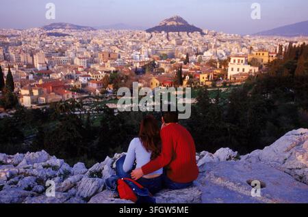Giovani innamorati osservano il tramonto su Atene. Foto Stock