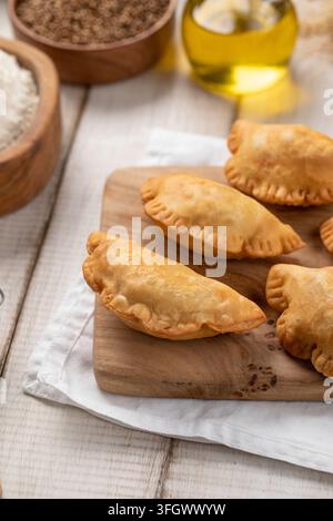 Mini pasticcini chebureki fritti su tavola di legno Foto Stock