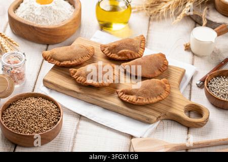 Mini pasticcini chebureki fritti su tavola di legno Foto Stock