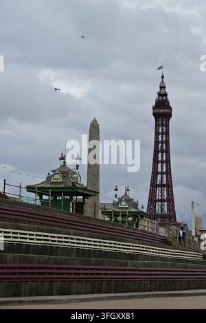 Promenade costiera con la torre di Blackpool, gradini a terrazzo e cielo cupo Foto Stock
