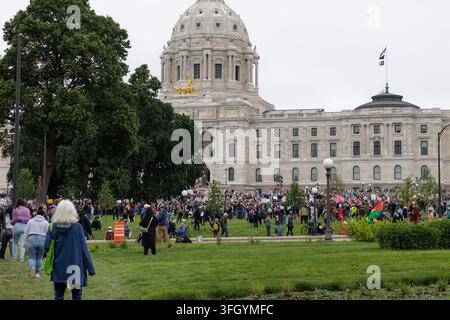 Saint Paul, Minnesota, USA - 14 giugno 2025: Donna anziana si dirige verso una grande folla al State Capitol per la prima protesta anti-Trump "No Kings". Foto Stock