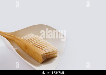Concetto di pulizia eco spazzola di bambù su paletta minimal sfondo bianco spazio copia Foto Stock