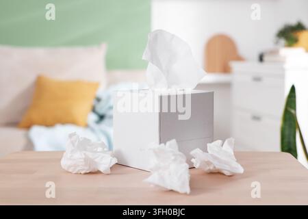 Scatola di fazzoletti di carta e tovaglioli usati su un tavolo al chiuso Foto Stock