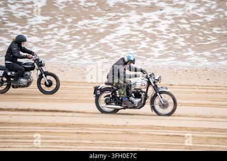 Due moto sfrecciano sulla sabbia di Bridlington South Beach durante Race the Waves 2026, inclusa una moto classica numerata 10 Foto Stock