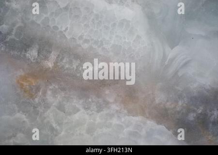 Vista ravvicinata di una lastra di pietra naturale in marmo o onice con motivi nuvolosi e venati Foto Stock