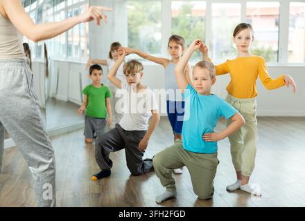 Bambini preadolescenti positivi che imparano a ballare il valzer a coppie in classe di coreografia Foto Stock