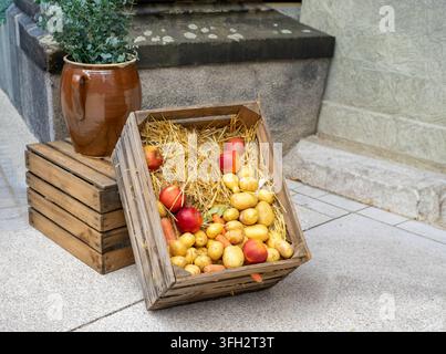 Cassa di legno con paglia e verdure fresche al mercato autunnale Foto Stock