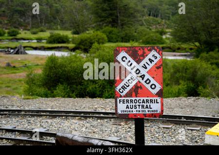 Insegna di avvertimento per passaggio a livello rossa e consumata per il treno più a sud del mondo nel Parco Nazionale della Terra del Fuoco. Foto Stock