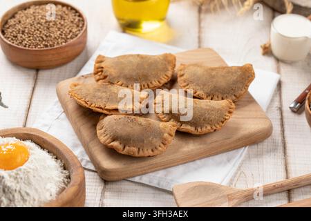 Mini pasticcini chebureki fritti su tavola di legno Foto Stock