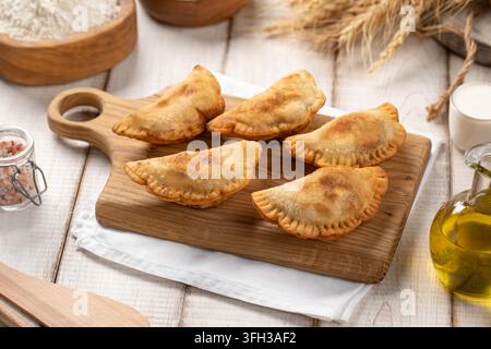 Mini pasticcini chebureki fritti su tavola di legno Foto Stock