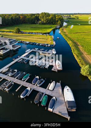 Fotografia aerea verticale ad angolo alto con drone che cattura un bacino di marina moderno trasformato in vie d'acqua rurali di polder vicino a Warmond, Olanda Meridionale, Paesi Bassi Foto Stock