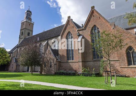 Utrecht, Paesi Bassi. Nicolaikerk storica (Chiesa di San Nicola) con architettura gotica in mattoni, grandi finestre ad arco e un alto campanile contro un Foto Stock