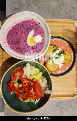 Saltibarsciai lituani tradizionali, frittelle di patate e verdure fresche servite su un vassoio di legno Foto Stock