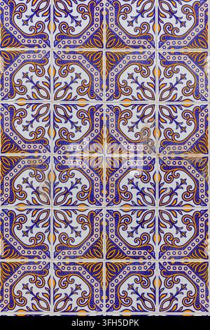 Primo piano di piastrelle ceramiche smaltate portoghesi tradizionali con un motivo decorativo blu, giallo e bianco ripetuto e ornato. Foto Stock