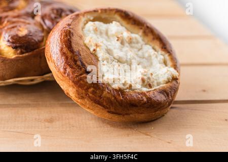 Pasticceria tradizionale al formaggio di cottage con crosta dorata su tavolo di legno Foto Stock