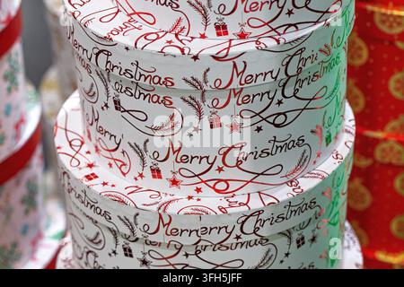 Primo piano di una pila di scatole regalo rotonde con iscrizioni natalizie festive. Foto Stock