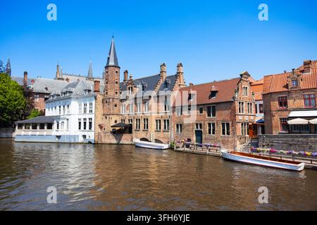 Vista panoramica del canale Rozenhoedkaai o Rosary Quay con barca turistica a Bruges, Belgio Foto Stock