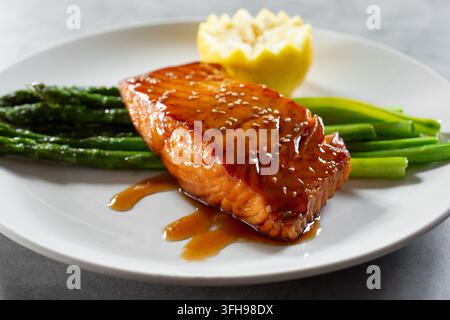 Una vista di un filetto di salmone con asparagi. Foto Stock