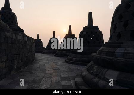 Il più grande tempio buddista del mondo Borobudur durante l'alba di prima mattina. Colori meravigliosi e poche nuvole nel cielo Foto Stock