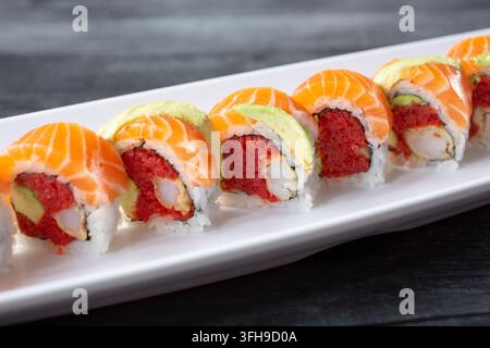 Una vista ravvicinata di un rotolo di sushi al salmone, tonno ahi e avocado, con gamberi tempura. Foto Stock