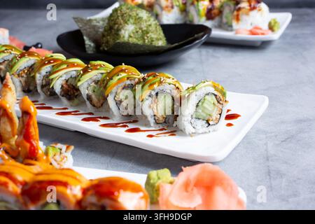 Una vista di diversi rotoli di sushi, tra cui un roll drago. Foto Stock