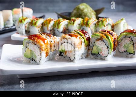 Una vista di diversi rotoli di sushi, tra cui un roll drago. Foto Stock