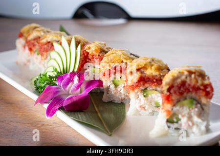 Una vista ravvicinata di un rotolo di sushi con tonno ahi, escolar, carne di granchio imitata e avocado. Foto Stock