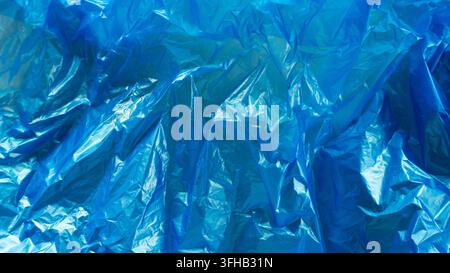 Fondo astratto con texture di borsa di plastica blu accartocciata vivace Foto Stock