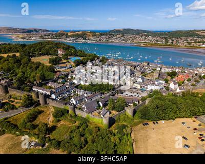 Veduta aerea delle mura medievali che circondano la città di Conwy, l'estuario del fiume Conwy e le barche ancorate in acque libere oltre, Galles del Nord Foto Stock