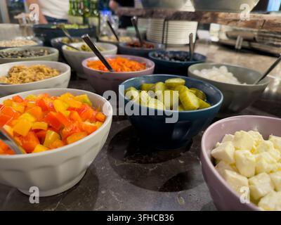 Prima vista di un buffet self-service con ingredienti freschi e vivaci, tra cui peperoni, sottaceti, formaggio feta, che promuove scelte alimentari sane Foto Stock