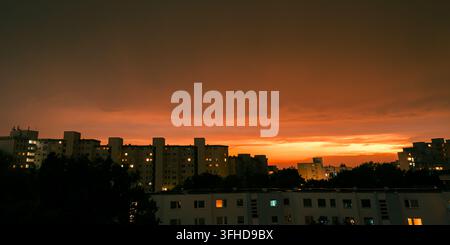 Tramonto arancione drammatico su una città residenziale dopo un temporale Foto Stock