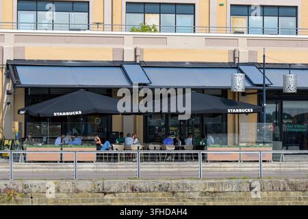 Bordeaux, Francia - 1 settembre 2026: Persone che prendono il caffè nella filiale di Starbucks sul lungofiume a Bordeaux Foto Stock
