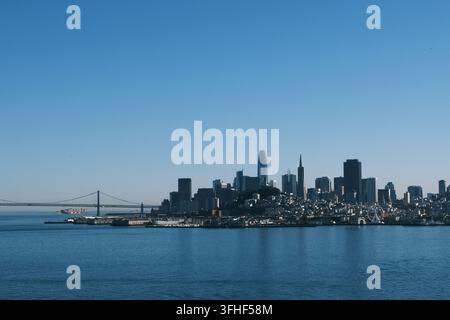 Skyline di San Francisco e Bay Bridge con nave da carico nella baia. Nave portacontainer e ponte accanto ai grattacieli del centro di San Francisco, California. Foto Stock