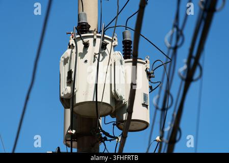 Trasformatori montati su pali della rete di distribuzione elettrica urbana Foto Stock