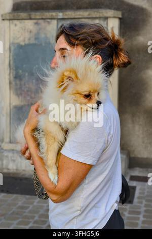 Giovane donna che porta il suo cane Pomerania – Tours, Indre-et-Loire (37), Francia. Foto Stock