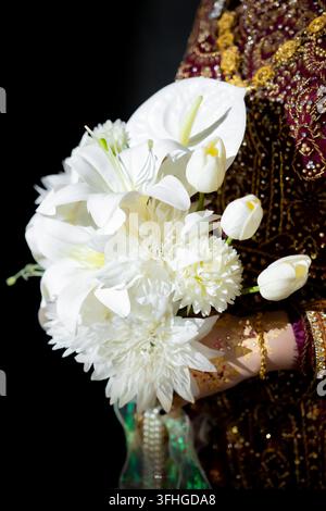 Bellissimo bouquet di fiori bianchi da matrimonio tenuto da una sposa in abito tradizionale Foto Stock