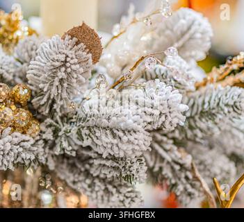 Decorazioni per rami di albero di Natale, ornamenti festivi, aghi di pino ghiacciati, accenti dorati, ambiente interno accogliente, luce calda e soffusa, stile elegante, ho Foto Stock