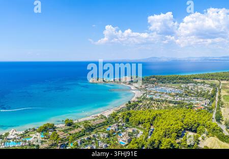 Vista aerea panoramica della costa della penisola di Kassandra a Calcidica, Grecia, con una baia turchese, foresta di pini e insediamenti costieri sparsi Foto Stock