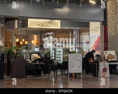 Poznań, Polonia - 31 gennaio 2026: locale Café Atelier con un'area salotto accogliente, esposizioni illuminate e menu in un contemporaneo R Foto Stock