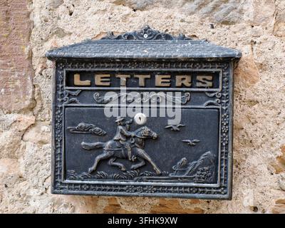 Cassetta delle poste antica in ghisa ornata con rilievo di cavaliere inciso e iscrizione LETTERS dorata, montata su un muro di pietra rustico a Marburg, Germania. Foto Stock