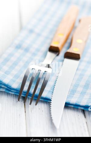 Coltello e forchetta su tovagliolo a quadri Foto Stock