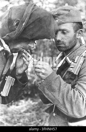 Soldati tedeschi sul fronte orientale, uno accende una sigaretta all'altro, giugno 1943. Foto Stock