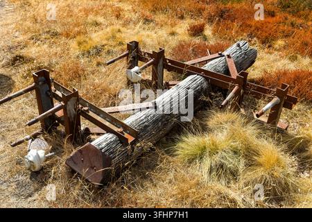 Palo elettrico in legno caduto con staffe metalliche arrugginite appoggiato su erica ed erba, attrezzatura industriale vintage lasciata a decadere sulla brughiera aperta del Galles Foto Stock