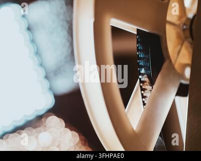 Vista frontale di un proiettore di film Super 8mm antico e vecchio stile, che proietta un fascio di luce in una stanza buia accanto a una pila di un Foto Stock