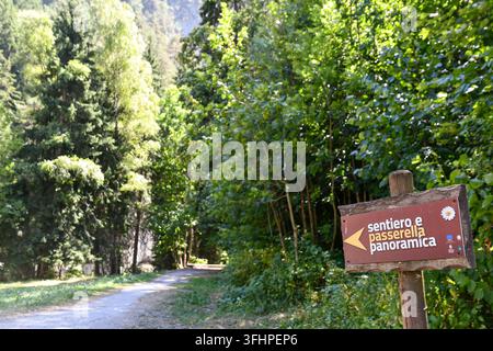 Segnale direzionale in legno per il sentiero panoramico accanto a un sentiero escursionistico sterrato a Pré Saint Didier, Valle d'Aosta, Italia Foto Stock