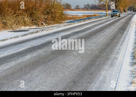 Auto su una strada ghiacciata in inverno. Foto Stock