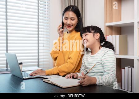 Felice madre e figlia trascorrono del tempo insieme a casa, sorridendo e impegnandosi in attività Foto Stock
